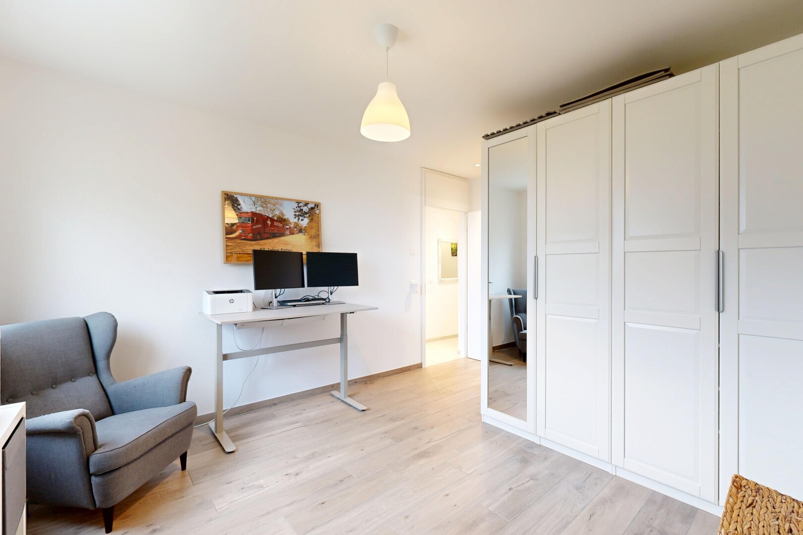 chambre avec éclairage suspendu, wood finish floor, sol en finition bois, drywall, et cloison sèche