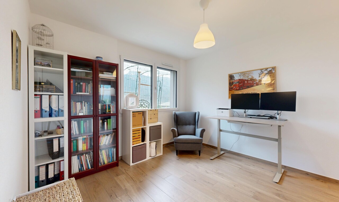 bureau avec éclairage suspendu, télévision, sol en finition bois, wood finish floor, et cloison sèche