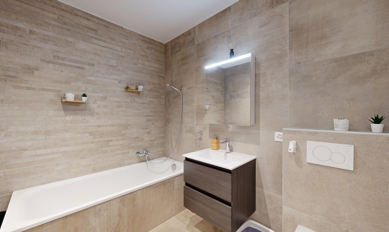 salle de bains avec tile wall, mur en carrelage, miroir, lavabo (ou coiffeuse selon le contexte), et salle de bain complète