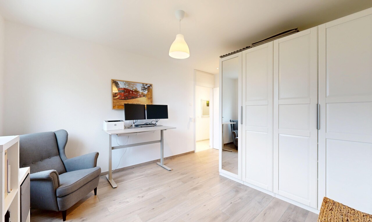 chambre avec éclairage suspendu, wood finish floor, sol en finition bois, drywall, et cloison sèche