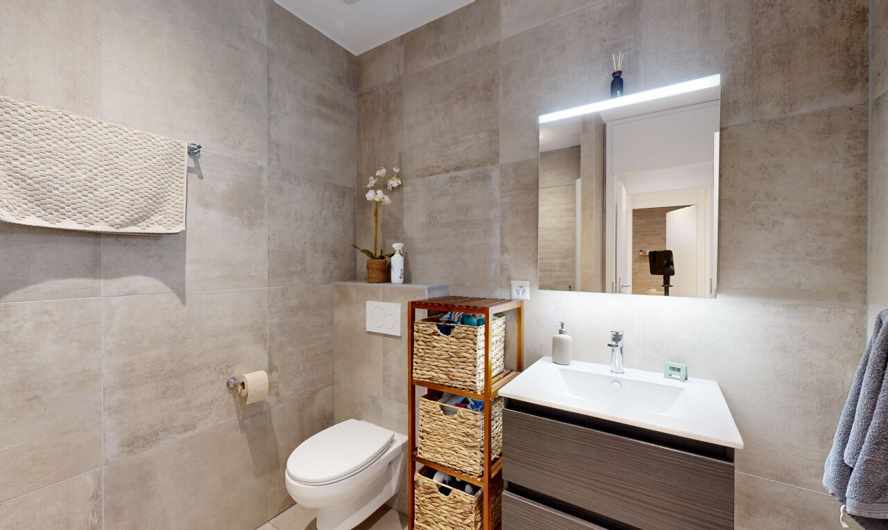 salle de bains avec tile wall, mur en carrelage, lavabo (ou coiffeuse selon le contexte), miroir, et inside property