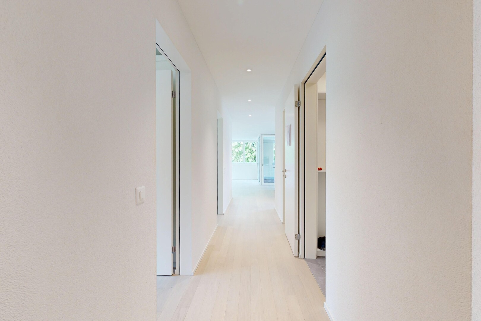 hall with light wood finished floors and recessed lighting