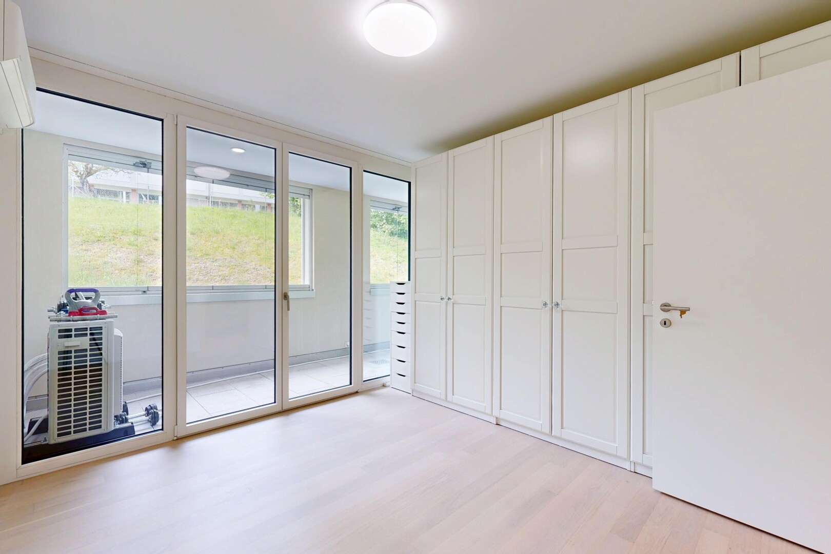 spare room with light wood-type flooring and a wall unit AC
