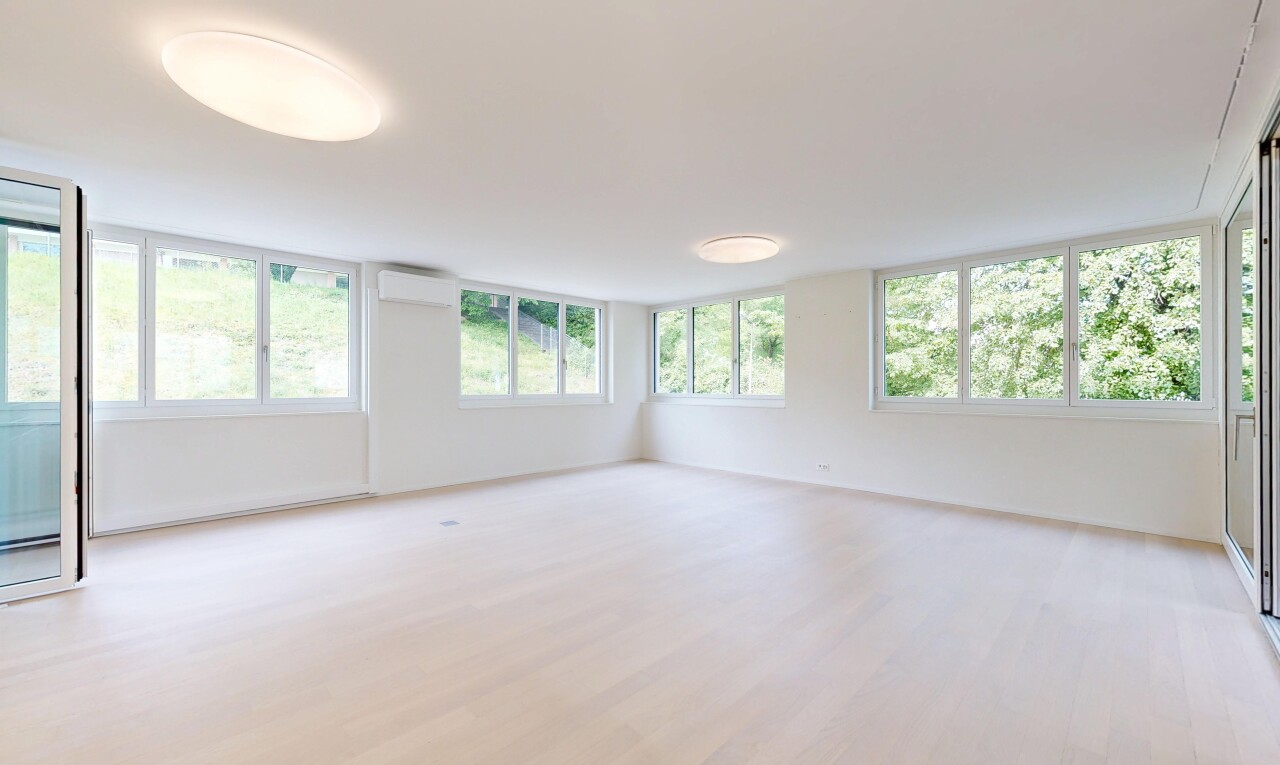 empty room featuring light wood-type flooring and a wall mounted air conditioner