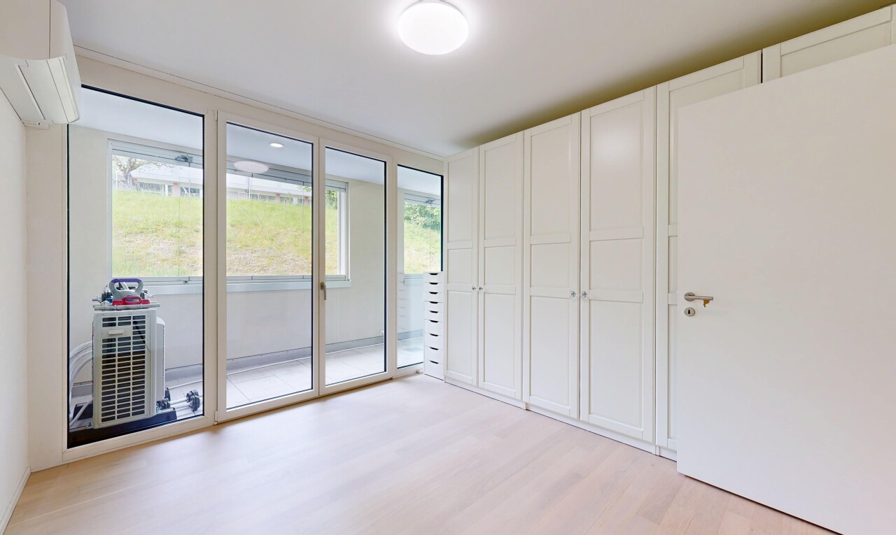 spare room with light wood-type flooring and a wall unit AC