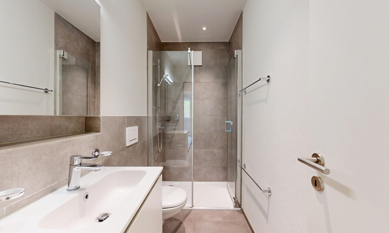 full bathroom featuring vanity, a shower stall, and tile walls