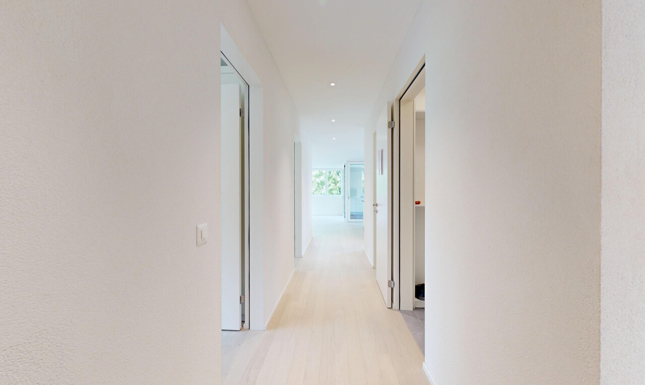 hall with light wood finished floors and recessed lighting