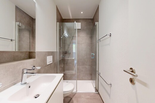 salle de bains avec lavabo (ou coiffeuse selon le contexte), light floor, miroir, douche, et salle de bain complète