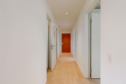 couloir avec cloison sèche, drywall, sol en finition bois, wood finish floor, et inside property