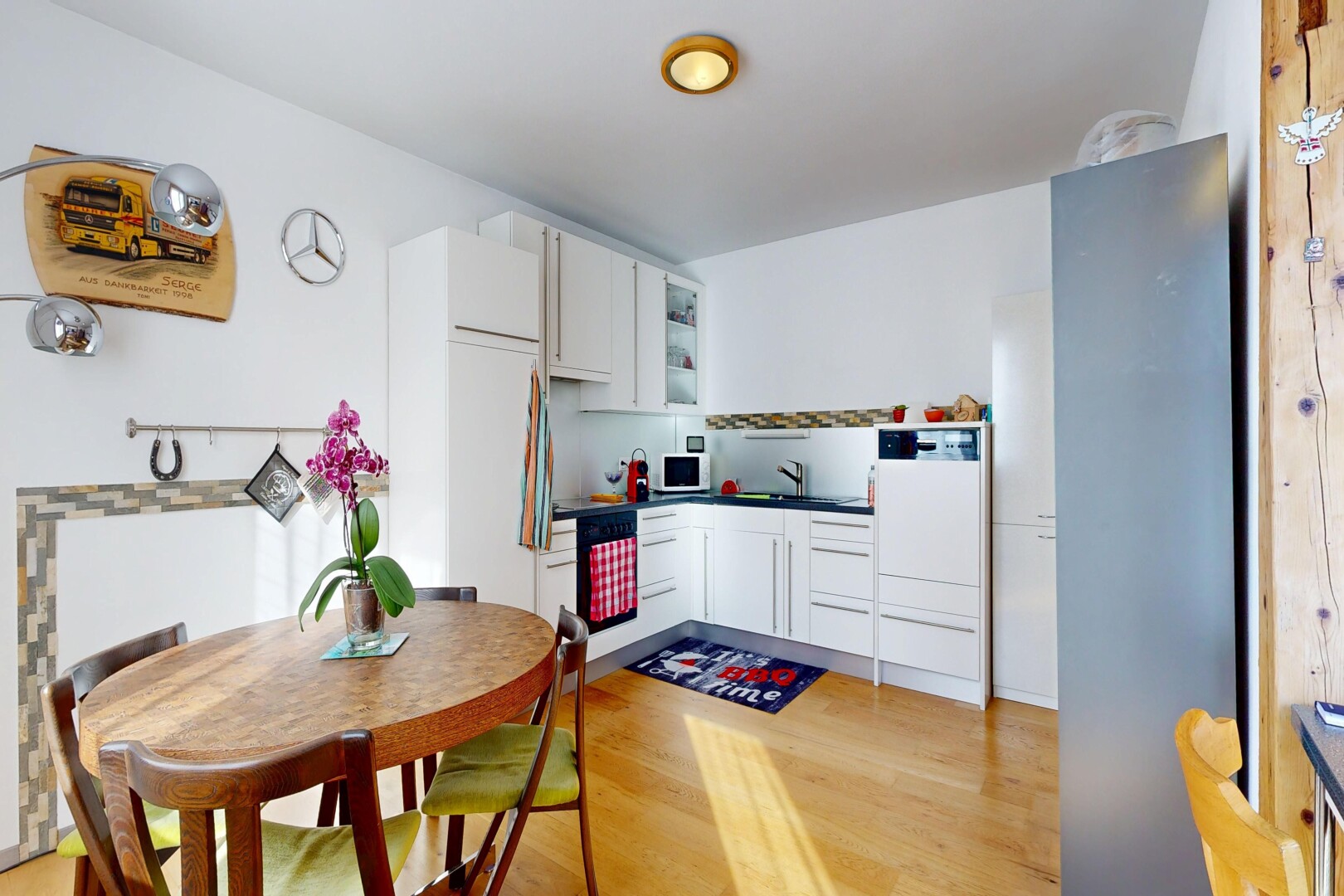 kitchen with white cabinetry, light wood-style floors, dark countertops, and white microwave