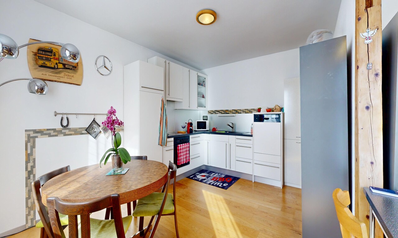 kitchen with white cabinetry, light wood-style floors, dark countertops, and white microwave