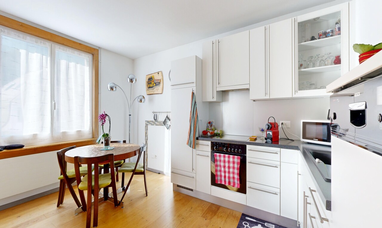 kitchen with glass insert cabinets, white cabinets, black oven, light wood-style flooring, and dark countertops
