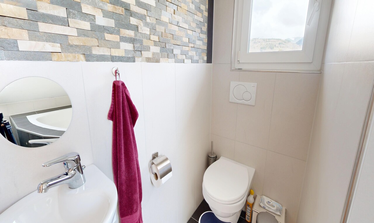 half bathroom featuring tile walls and a sink