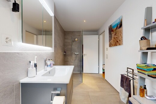 full bath with vanity, walk in shower, and tile walls