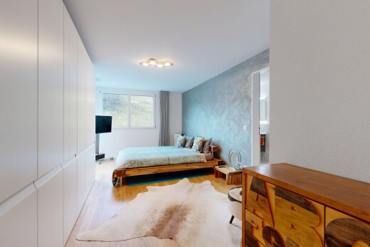 room / bedroom with light wood-style floors and a textured wall