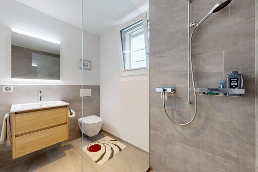 full bathroom with a walk in shower, vanity, tile walls, and light tile patterned floors