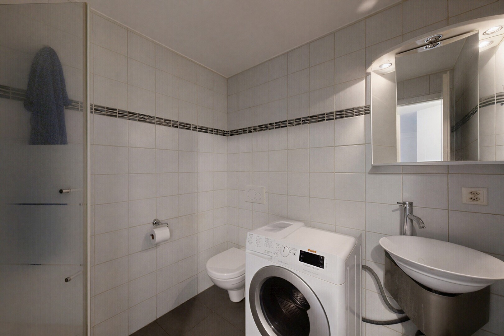 salle de bains avec mur en carrelage, tile wall, lave-linge et sèche-linge, miroir, et inside property