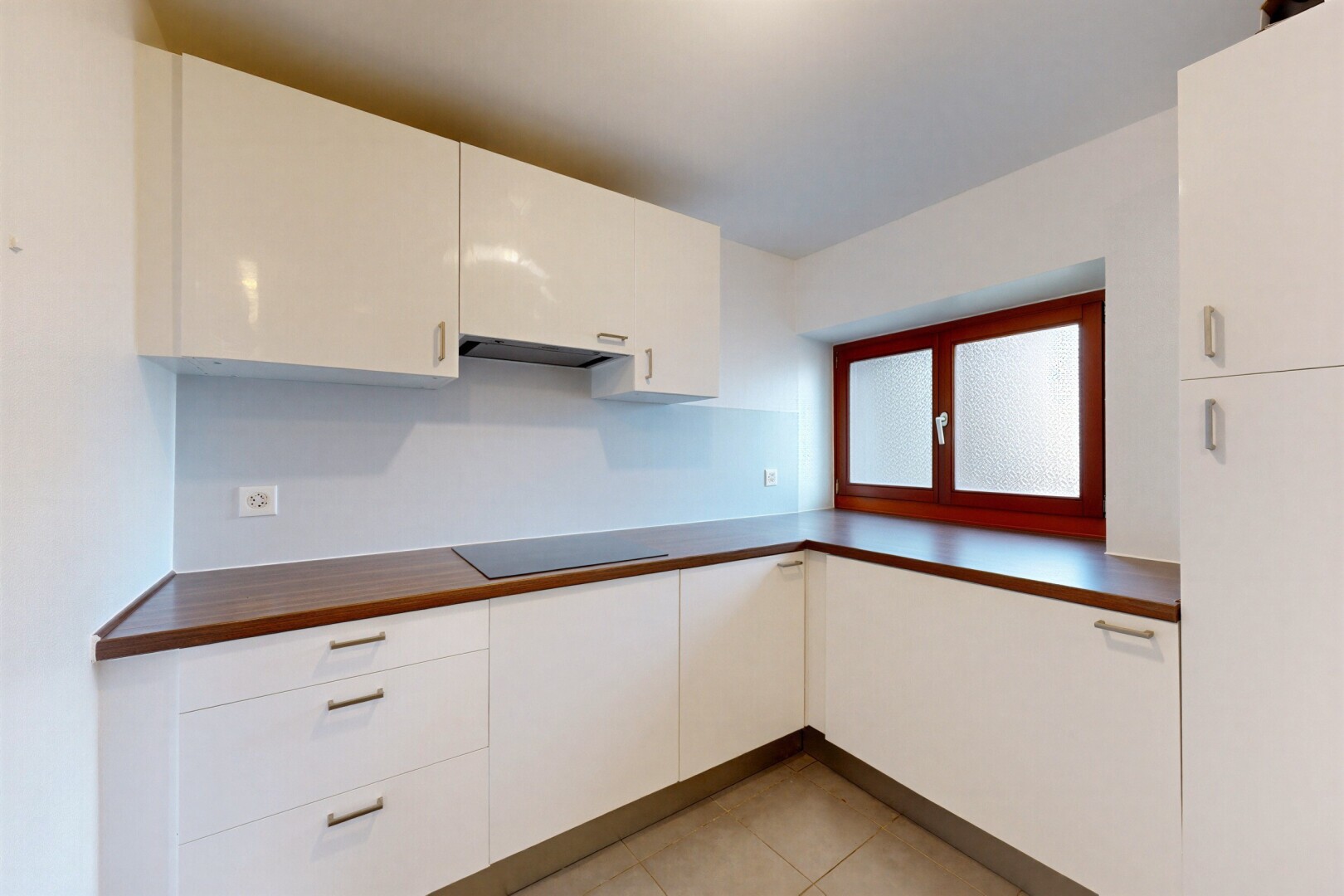 cuisine avec light floor, dark countertops, plans de travail, white cabinets, et armoires blanches