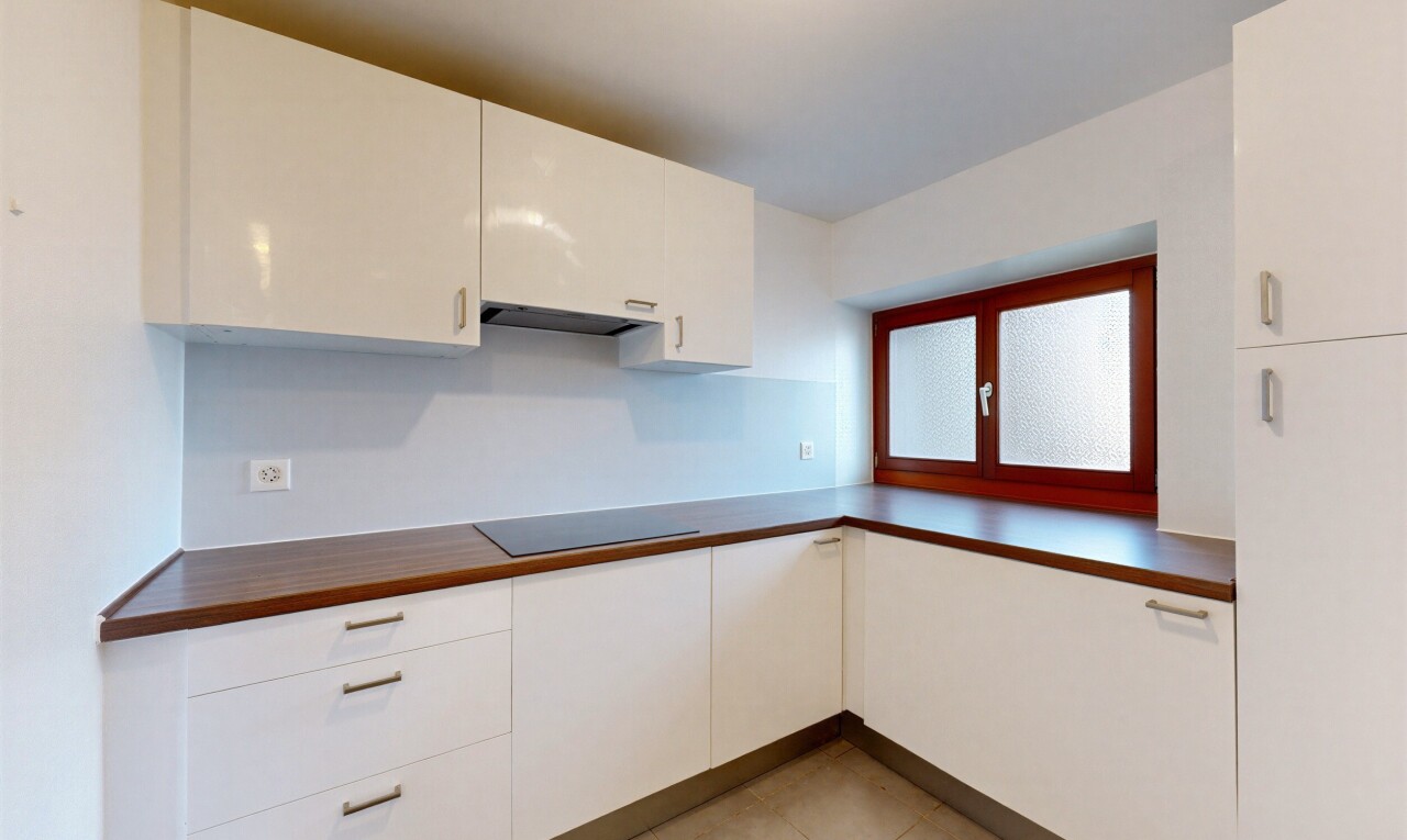 cuisine avec light floor, dark countertops, plans de travail, white cabinets, et armoires blanches