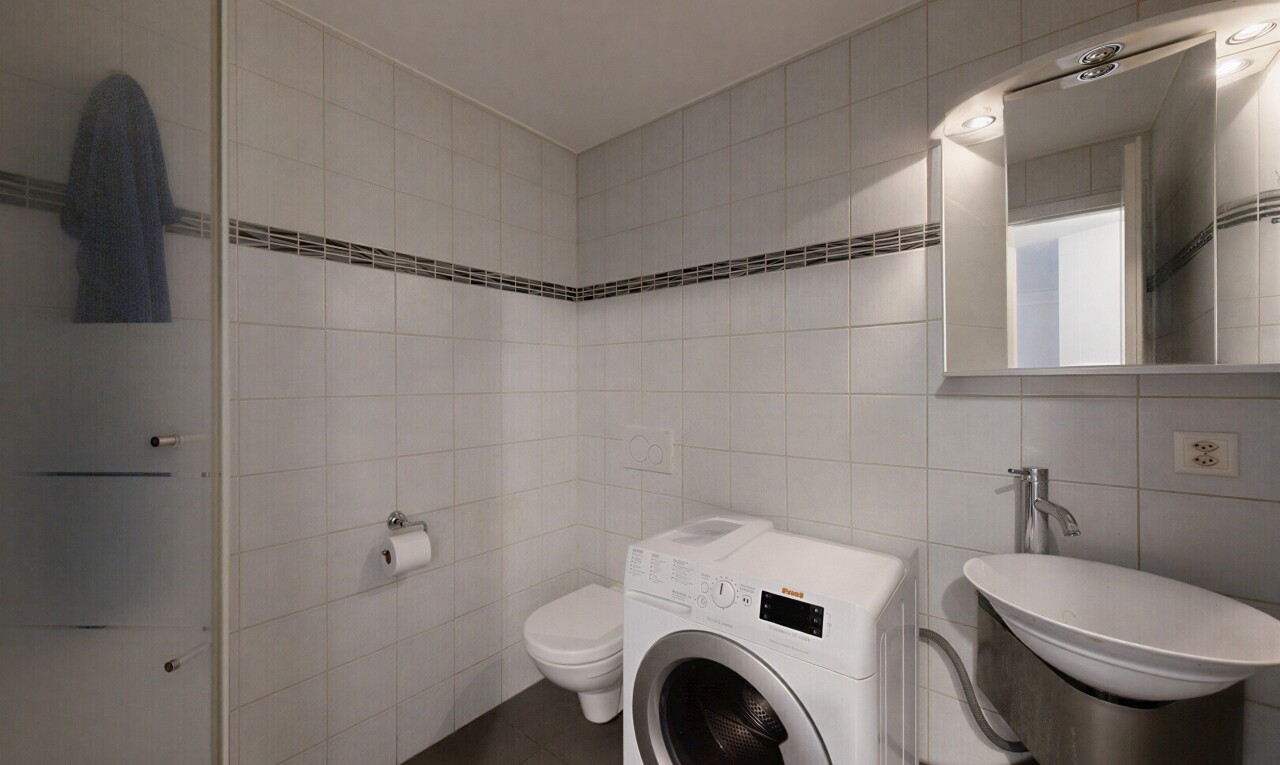 salle de bains avec mur en carrelage, tile wall, lave-linge et sèche-linge, miroir, et inside property