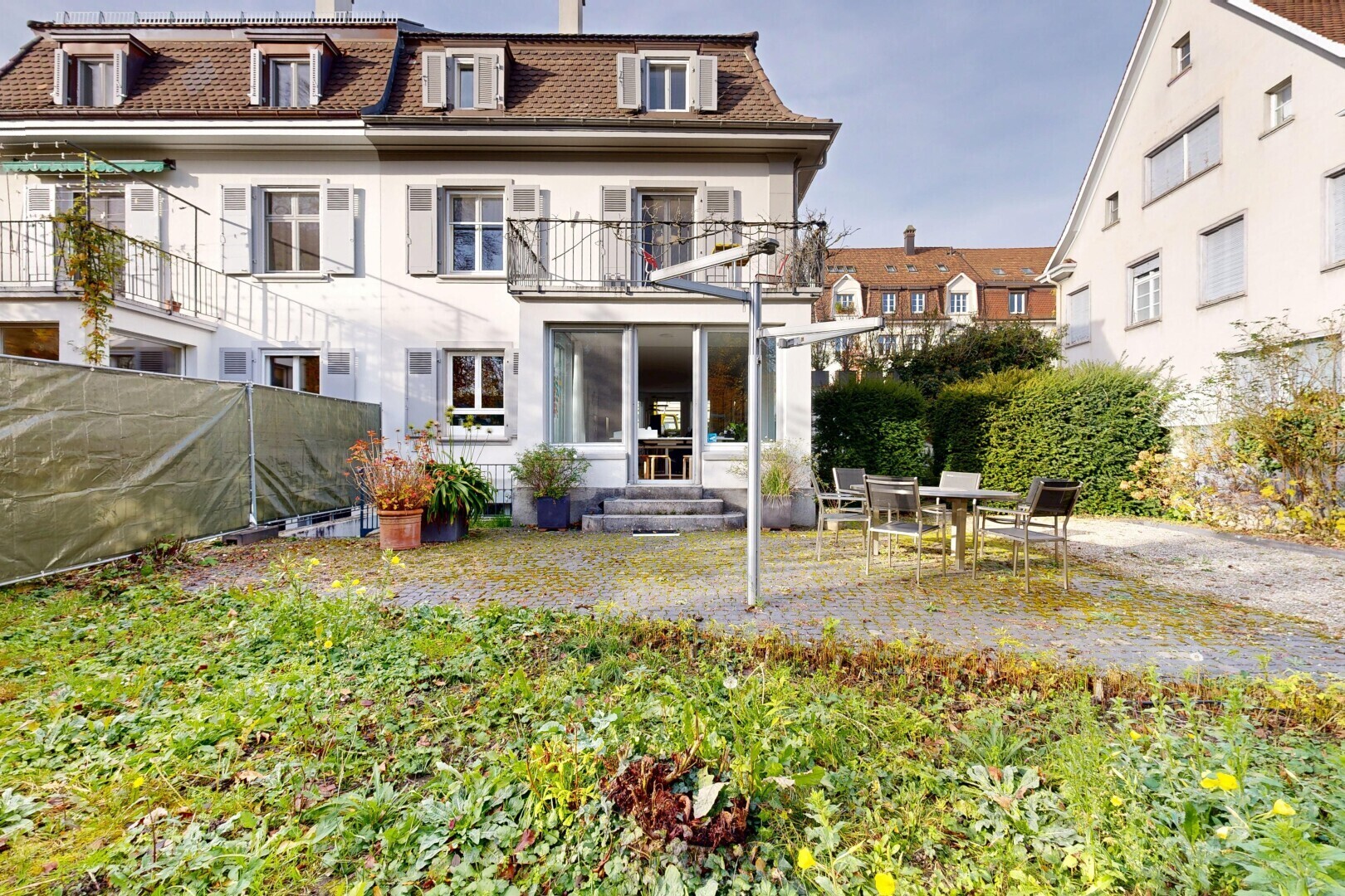 façade avec toit mansardé, balcon, terrasse, property visible, et bardage en stuc
