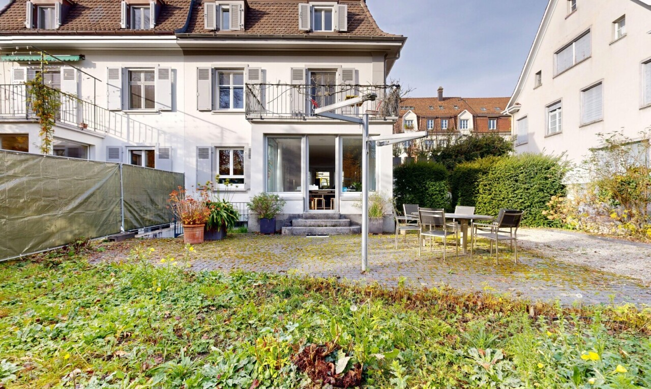 façade avec toit mansardé, balcon, terrasse, property visible, et bardage en stuc