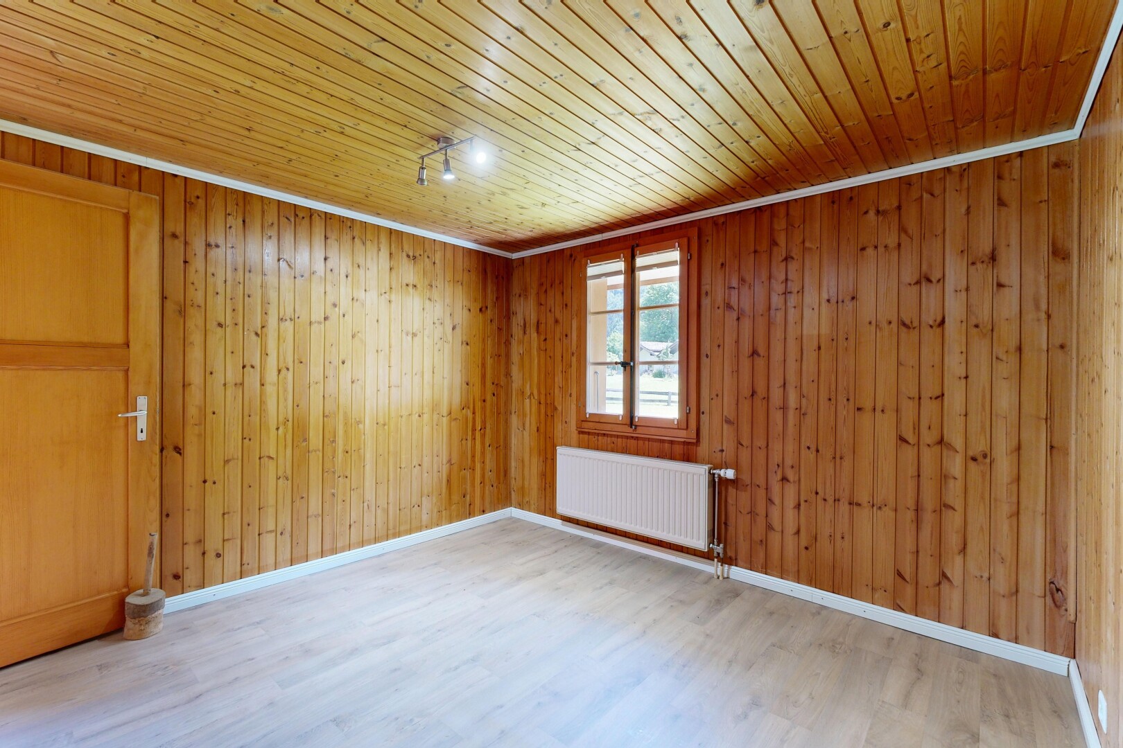 pièce vide avec sol en finition bois, wood finish floor, radiateur, inside property, et lumière naturelle