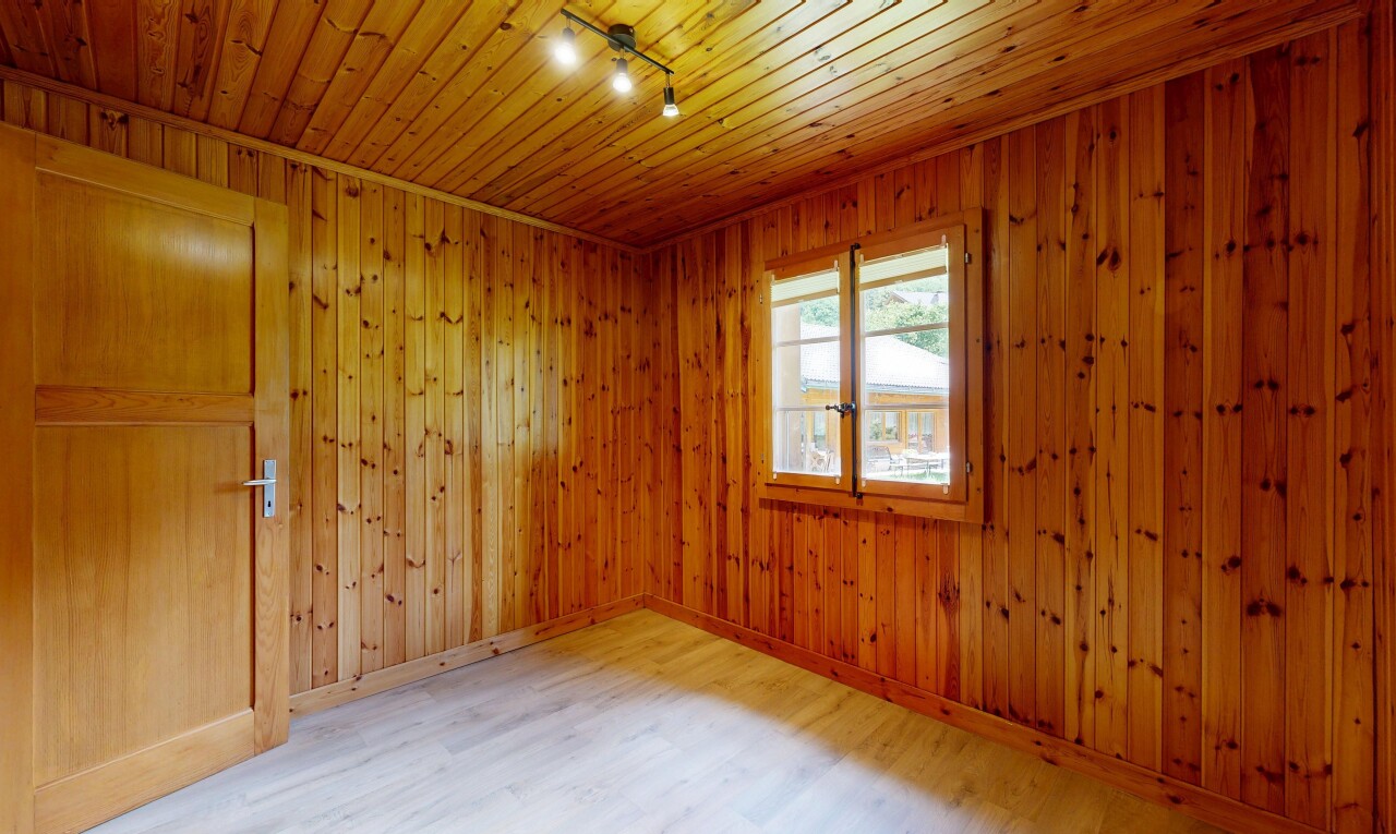 pièce vide avec éclairage sur rail, track lighting, sol en finition bois, wood finish floor, et plafond en bois