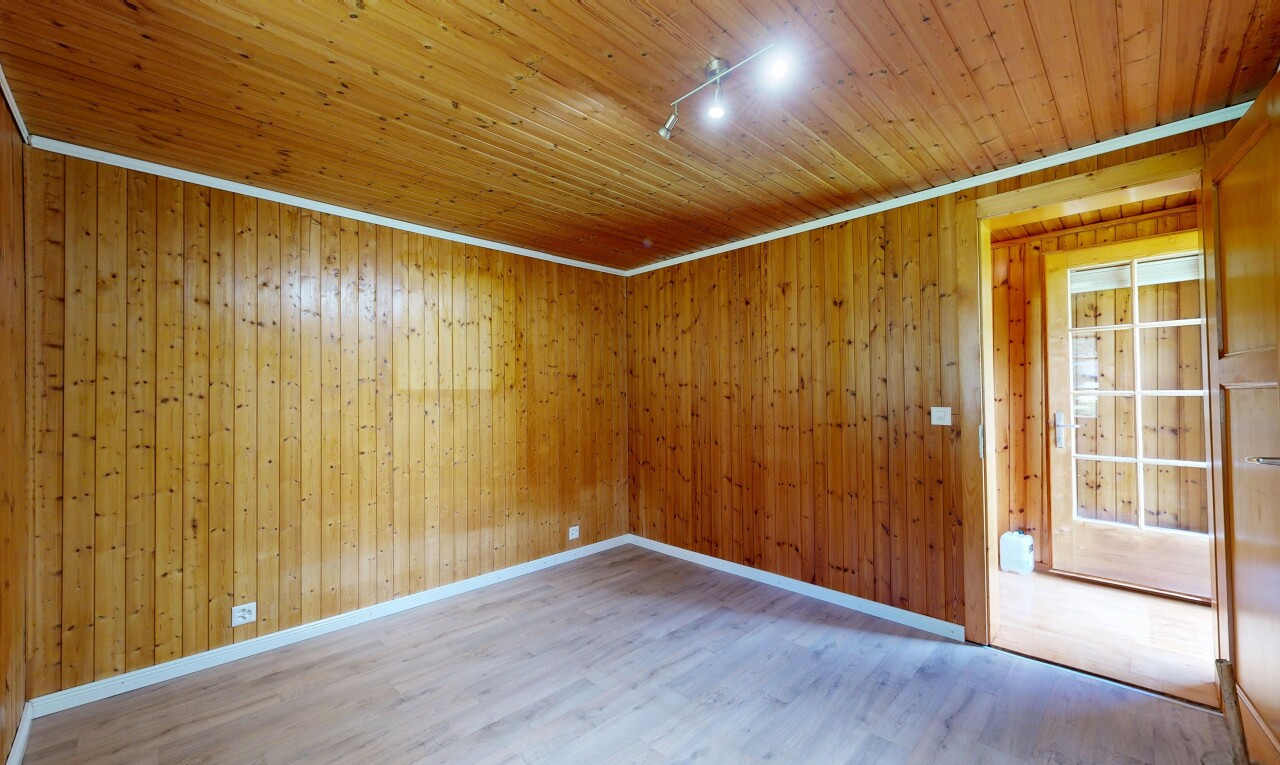 pièce vide avec éclairage sur rail, track lighting, sol en finition bois, wood finish floor, et plafond en bois
