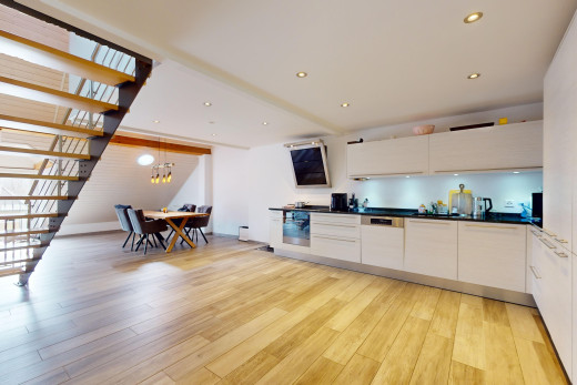 küche mit weiße schränke, parkettboden, bemerkenswerter kronleuchter, und arbeitsplatten