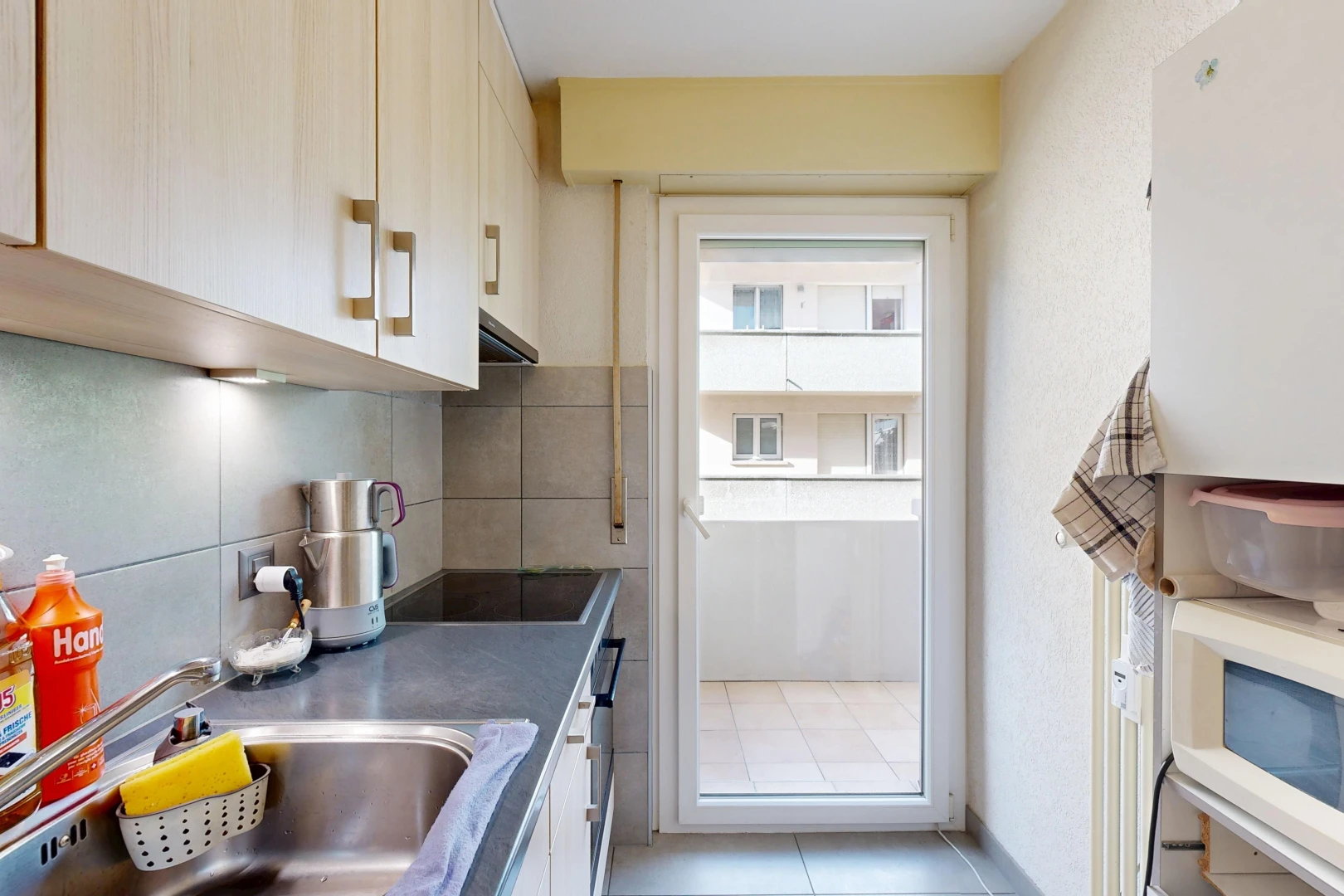 cuisine avec micro-ondes, évier, dosseret, backsplash, et inside property