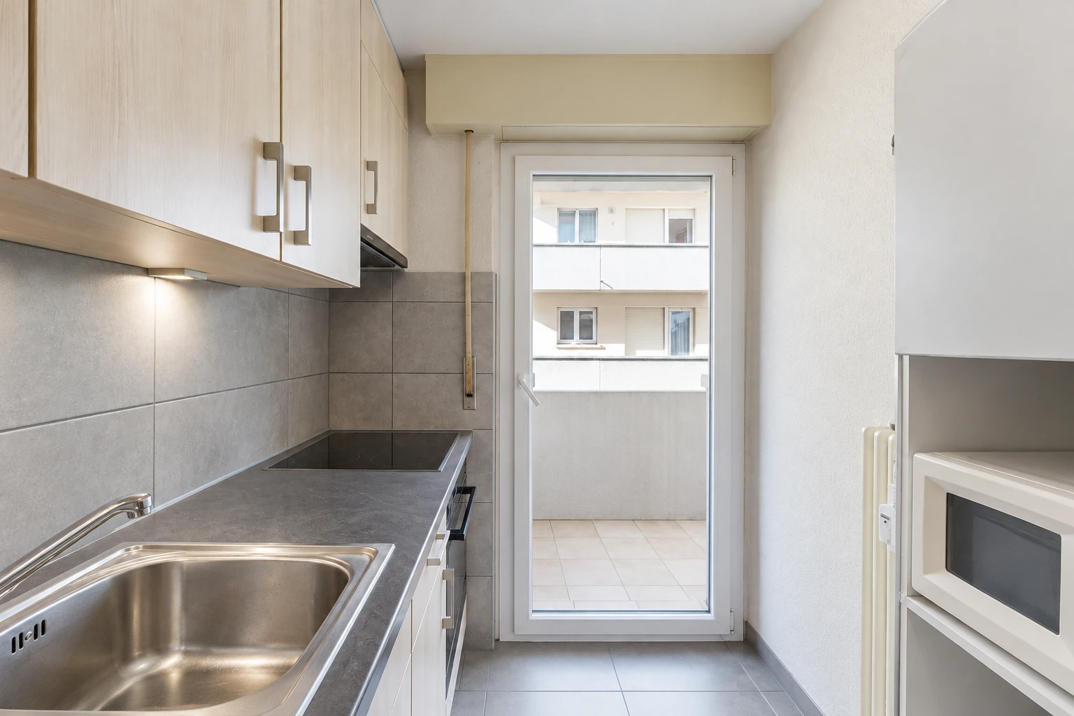 cuisine avec micro-ondes, évier, dosseret, backsplash, et inside property