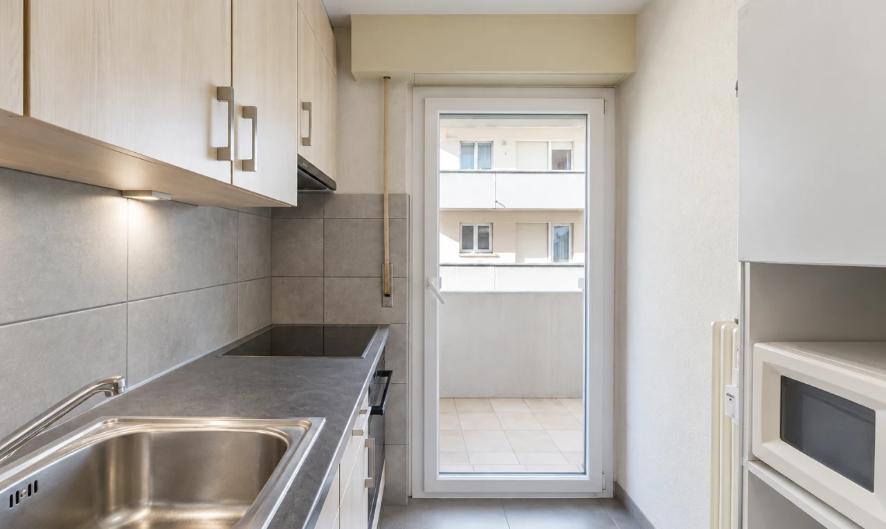 cuisine avec micro-ondes, évier, dosseret, backsplash, et inside property
