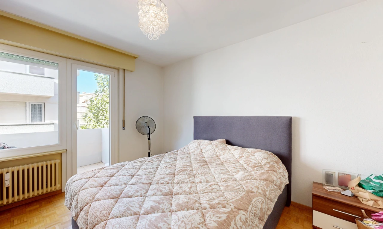 chambre avec radiateur, drywall, cloison sèche, wood finish floor, et sol en finition bois