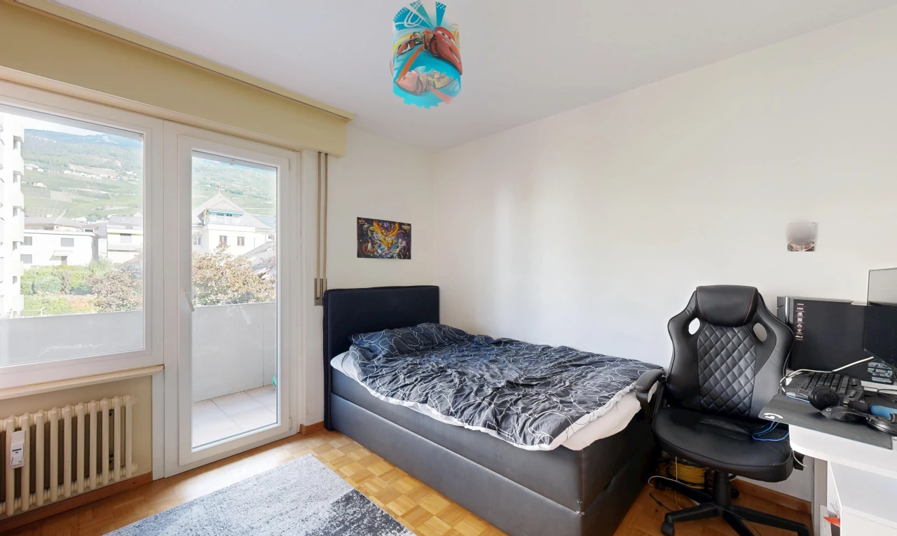chambre avec radiateur, accès à l'extérieur, wood finish floor, sol en finition bois, et drywall
