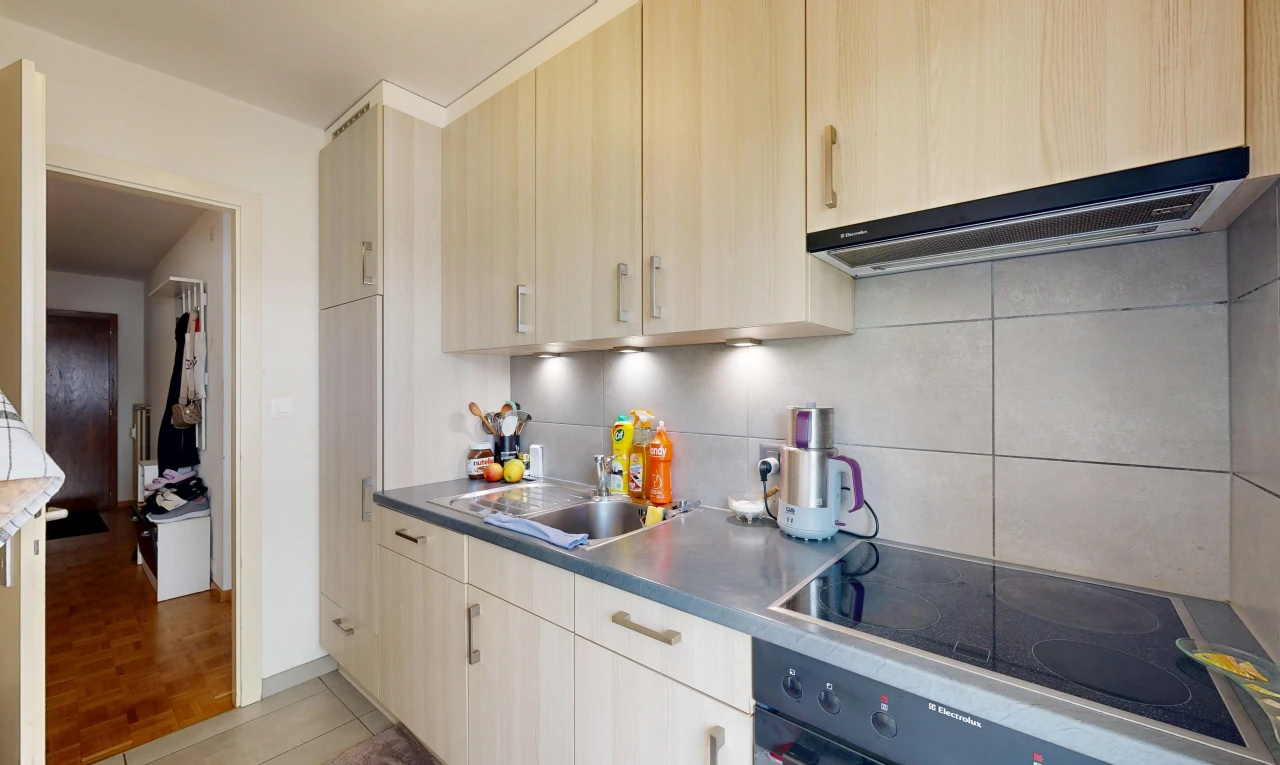 cuisine avec hotte, plaque de cuisson, light floor, évier, et plans de travail