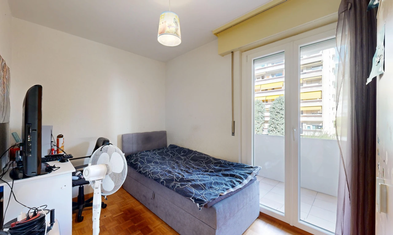 chambre avec wood finish floor, sol en finition bois, drywall, cloison sèche, et espace bureau