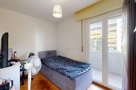 chambre avec wood finish floor, sol en finition bois, drywall, cloison sèche, et espace bureau