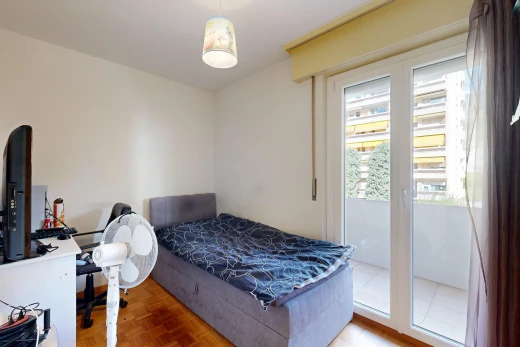 chambre avec wood finish floor, sol en finition bois, drywall, cloison sèche, et espace bureau