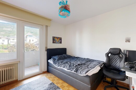 chambre avec radiateur, accès à l'extérieur, wood finish floor, sol en finition bois, et drywall