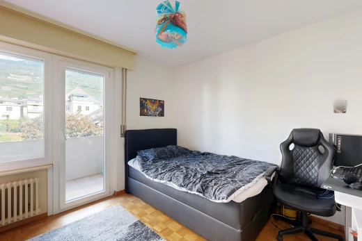 chambre avec radiateur, accès à l'extérieur, wood finish floor, sol en finition bois, et drywall