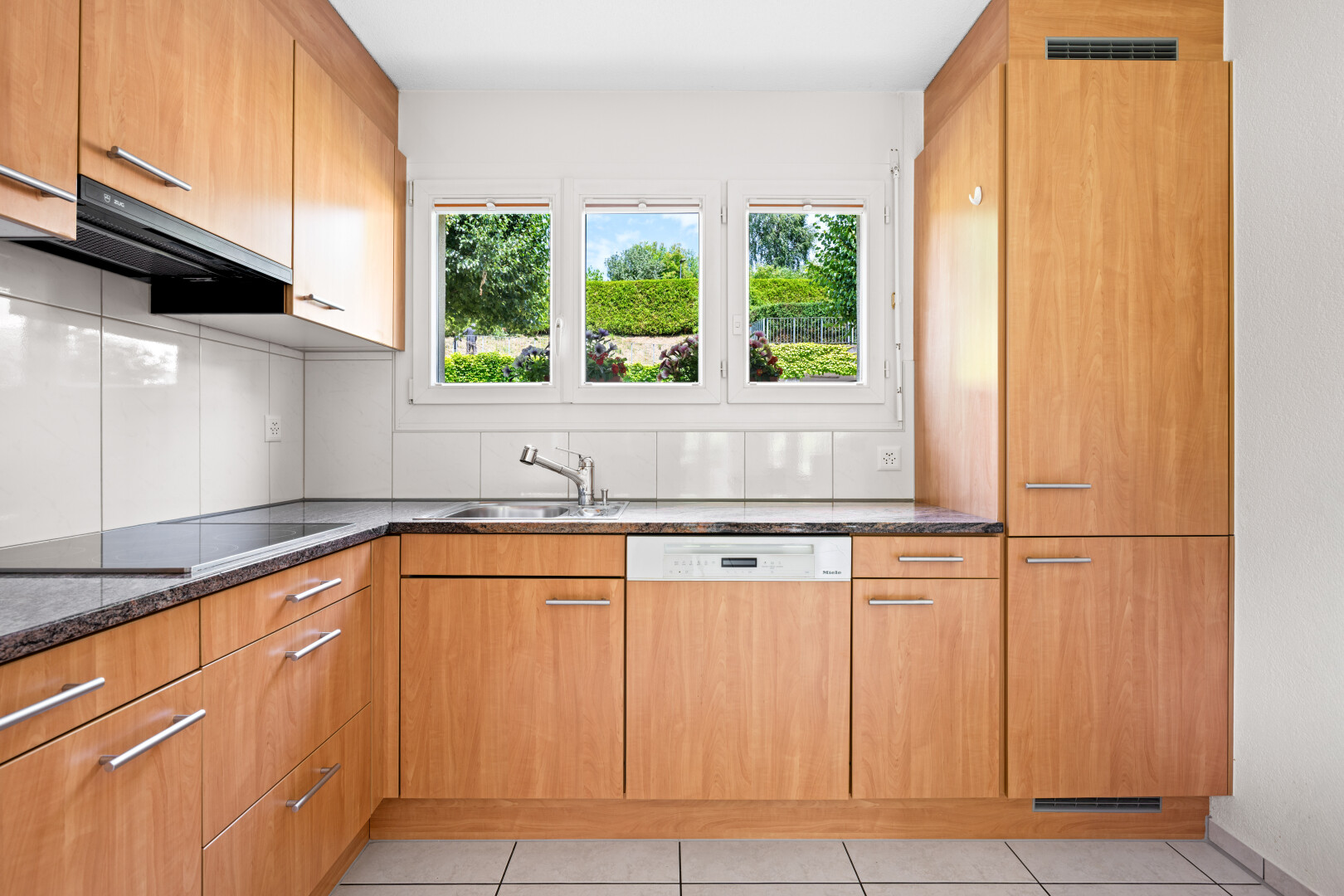 küche mit light floor, dark countertops, geschirrspülmaschine, inside property, und dunstabzugshaube