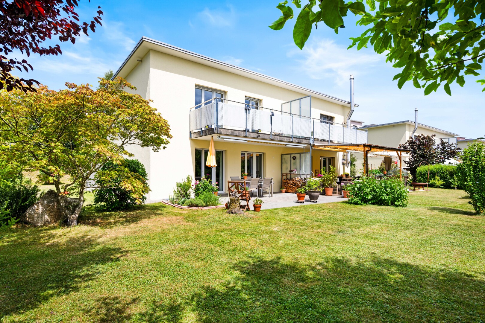 außenansicht mit rasen, stuckverkleidung, day time, property visible, und terrasse