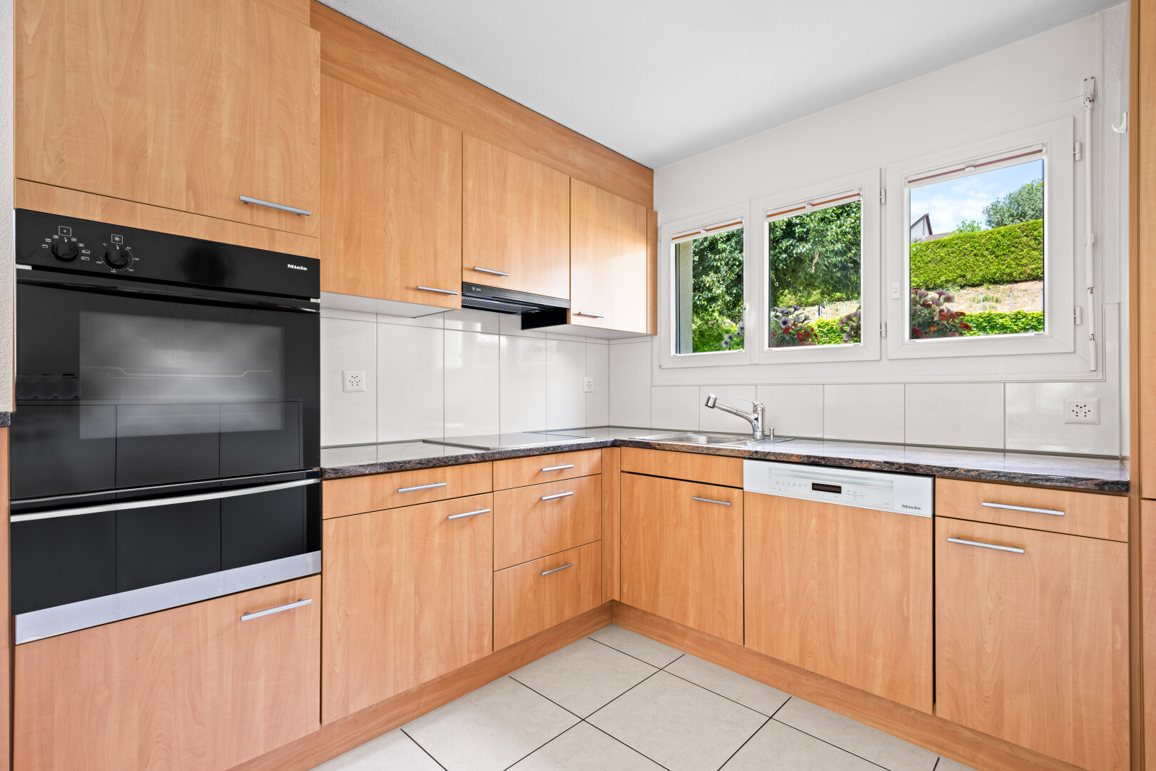 küche mit ofen, light floor, dark countertops, inside property, und geschirrspülmaschine