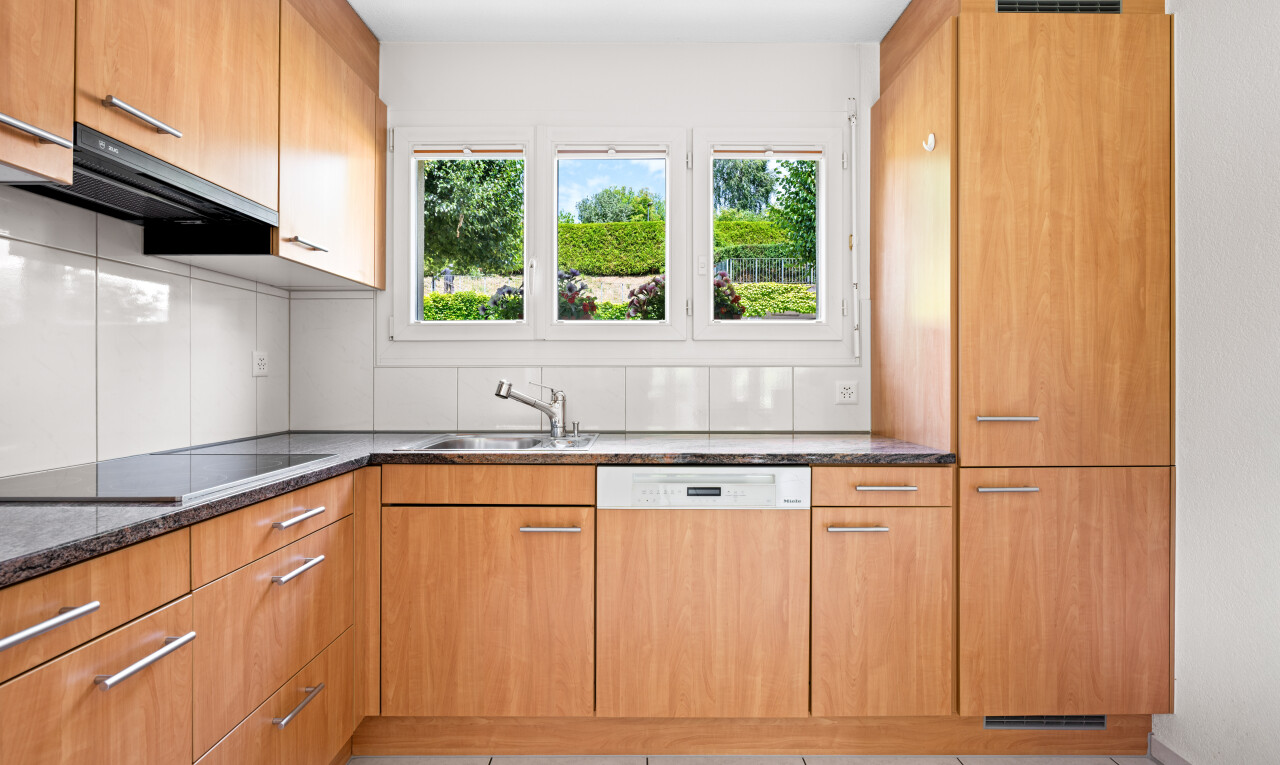 kitchen with dishwasher, extractor fan, black electric stovetop, wood finish cabinets, and light tile patterned flooring
