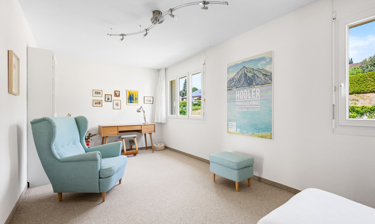 carpeted living room with baseboards and rail lighting