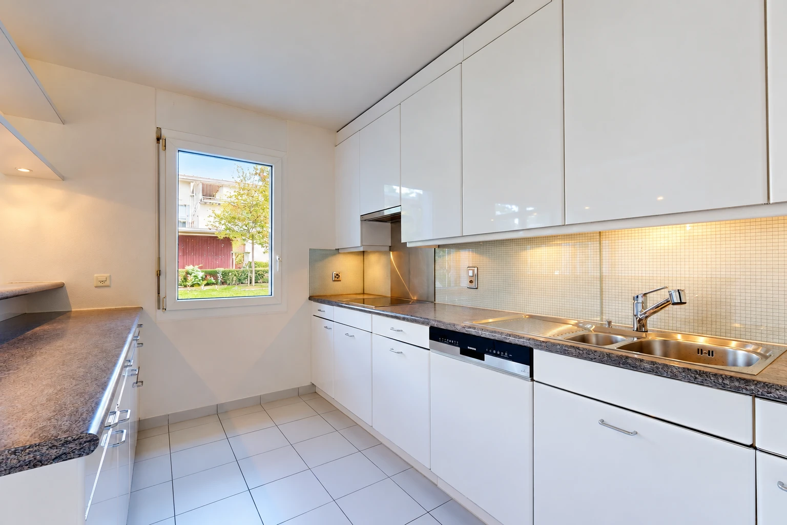 cuisine avec dark countertops, plans de travail, white cabinets, armoires blanches, et light floor