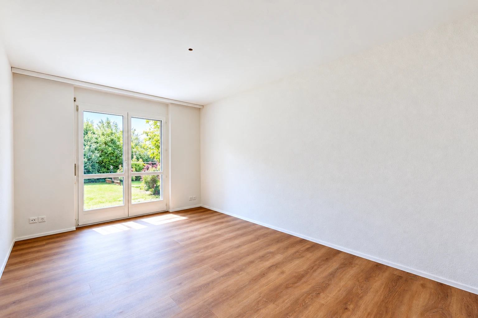 pièce vide avec accès à l'extérieur, cloison sèche, drywall, sol en finition bois, et wood finish floor