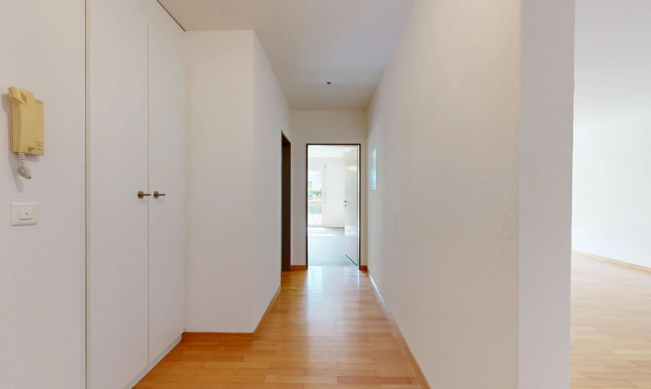 couloir avec light floor, wood finish floor, sol en finition bois, inside property, et drywall