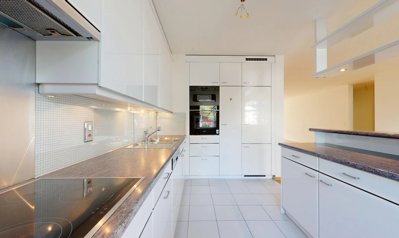 cuisine avec hotte, plaque de cuisson, plans de travail, dark countertops, et armoires blanches
